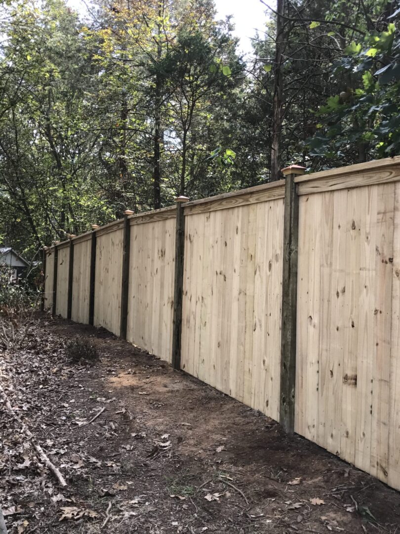 A wooden fence with trees in the background