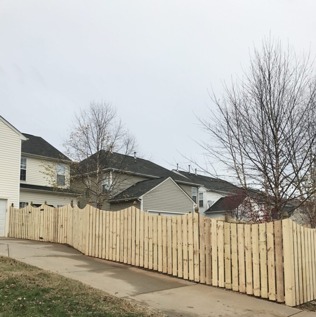 A wooden fence in front of houses.