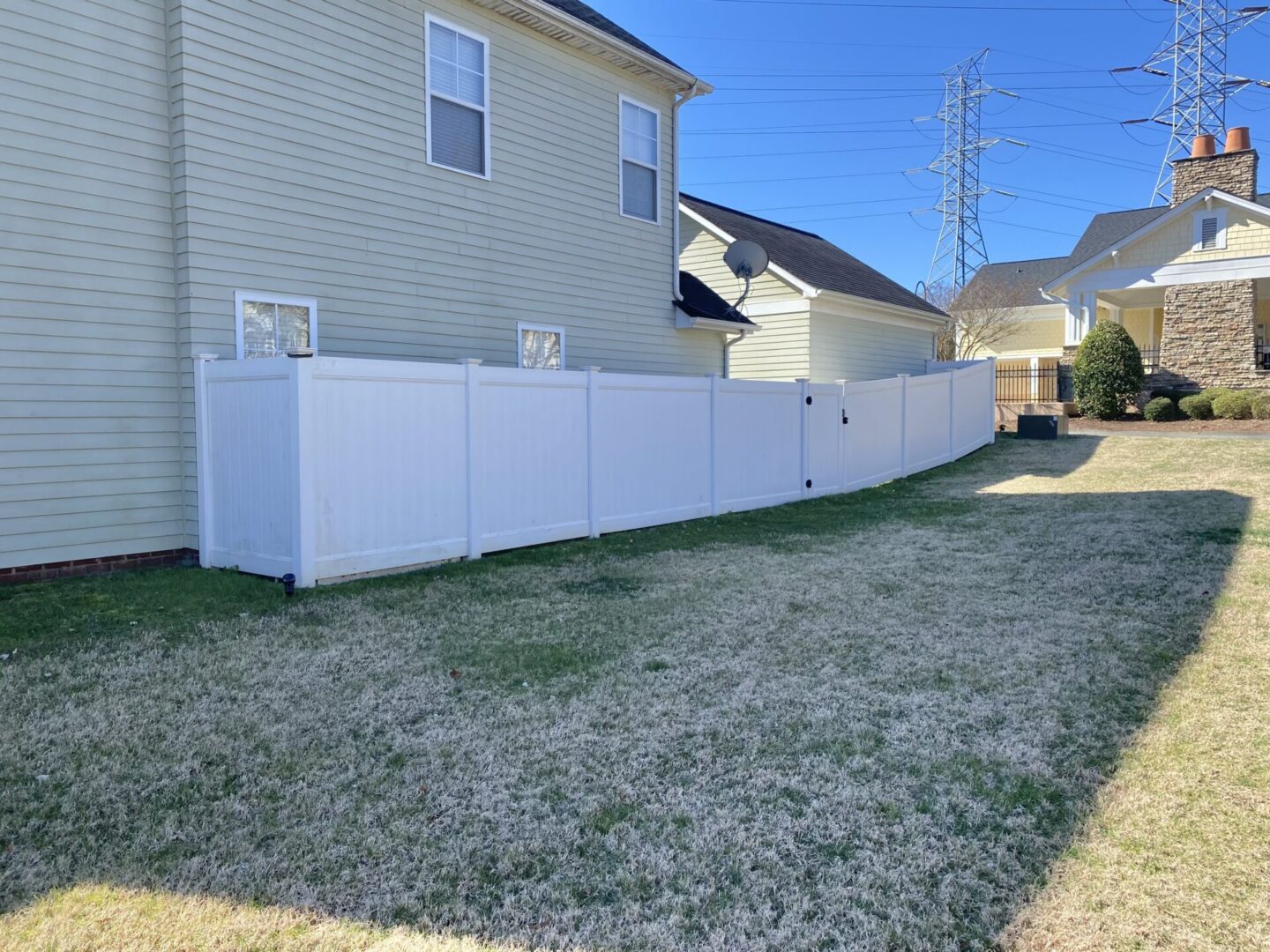 A white fence in the middle of a yard.