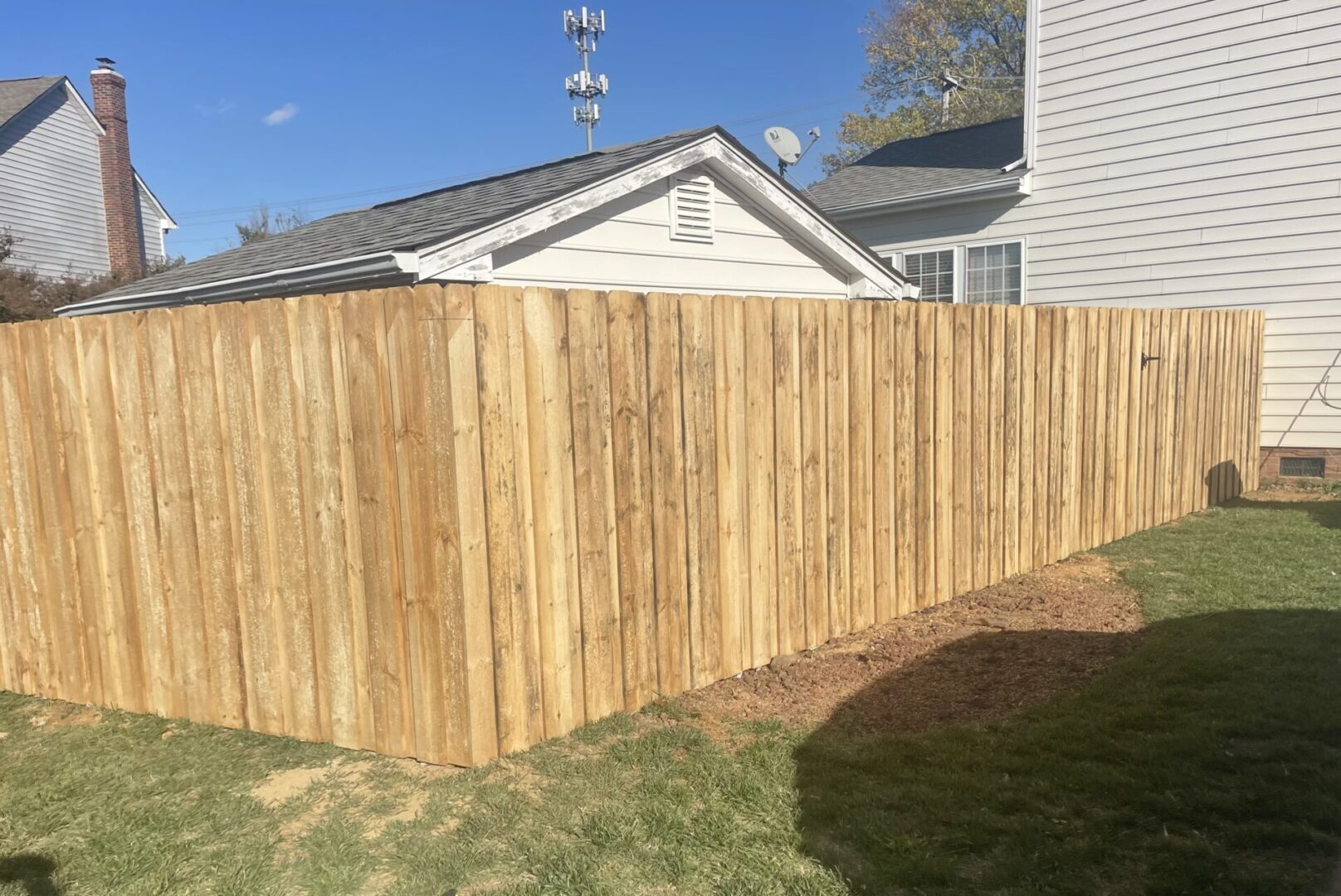 A wooden fence in the middle of a yard.