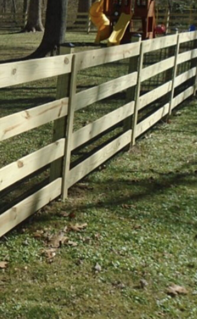 A wooden fence in the middle of a field.